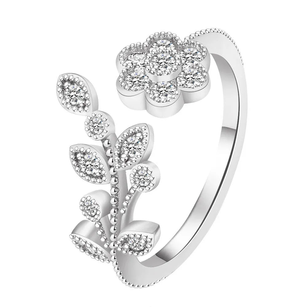 Close-up of a women's open ring with detailed floral leaf engraving, shown in gold colour finish.