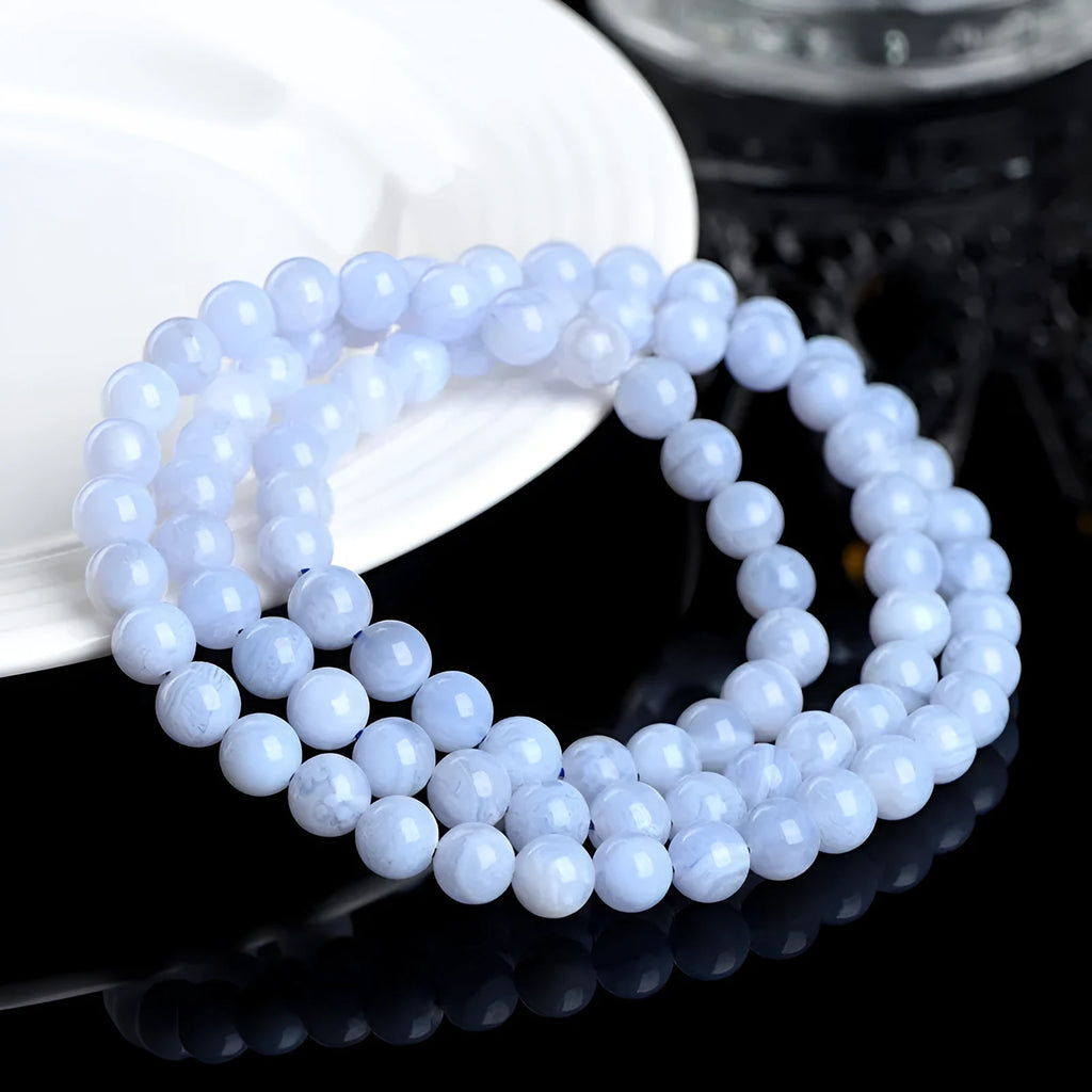 Blue agate beaded bracelet with multi-circle patterns and Ruyi design elements on a wrist.