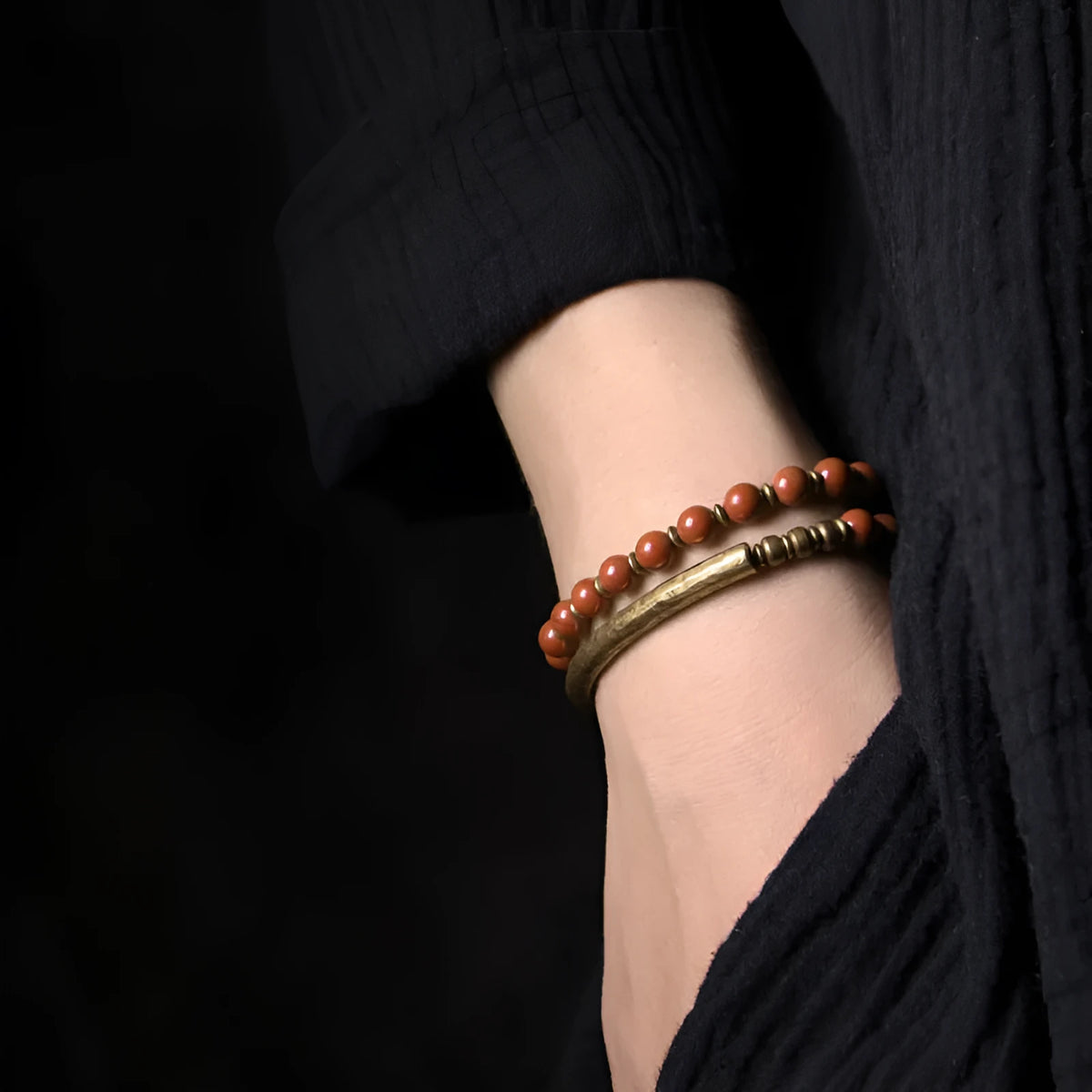 Layered multi-strand ethnic bracelet with natural stone beads and brass detailing on wrist