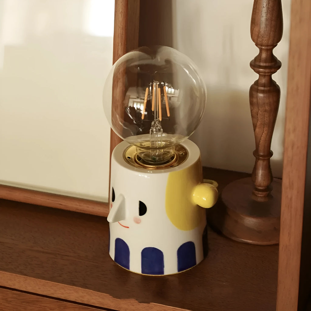 Handmade ceramic table lamp with ball-shaped shade on wooden surface
