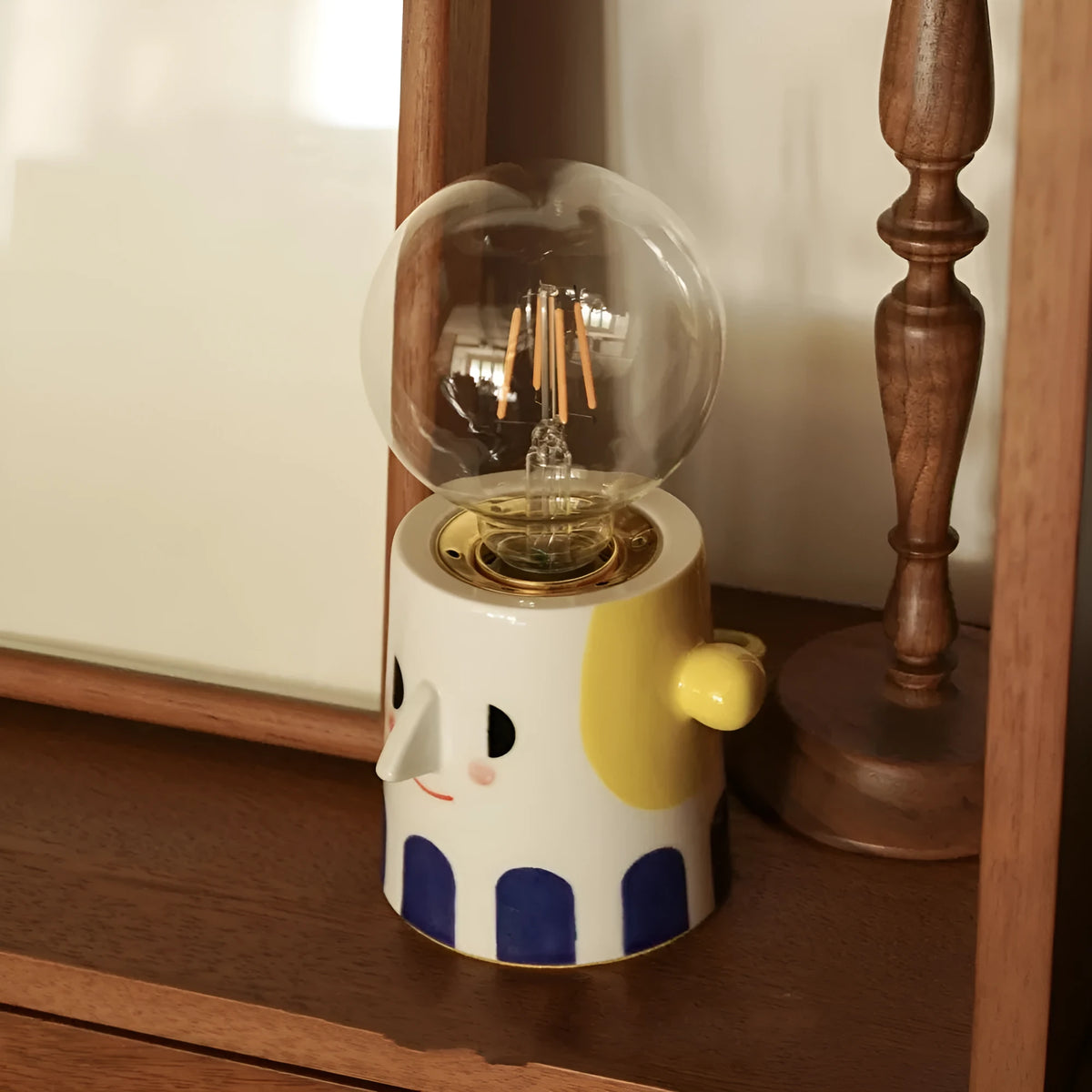 Handmade ceramic table lamp with ball-shaped shade on wooden surface