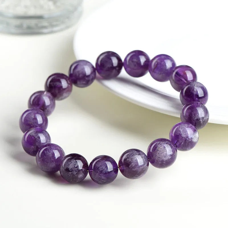 Natural feather amethyst crystal bracelet with geometric scattered beads and Ruyi design on a wrist.