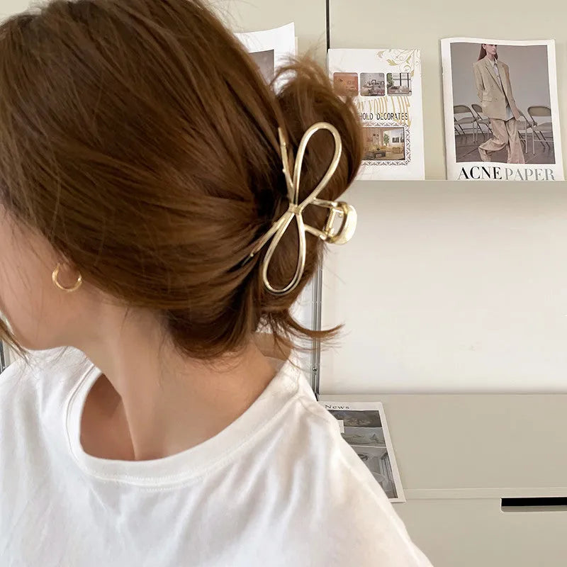 Gold and silver alloy hair barrettes with a bow design for women.