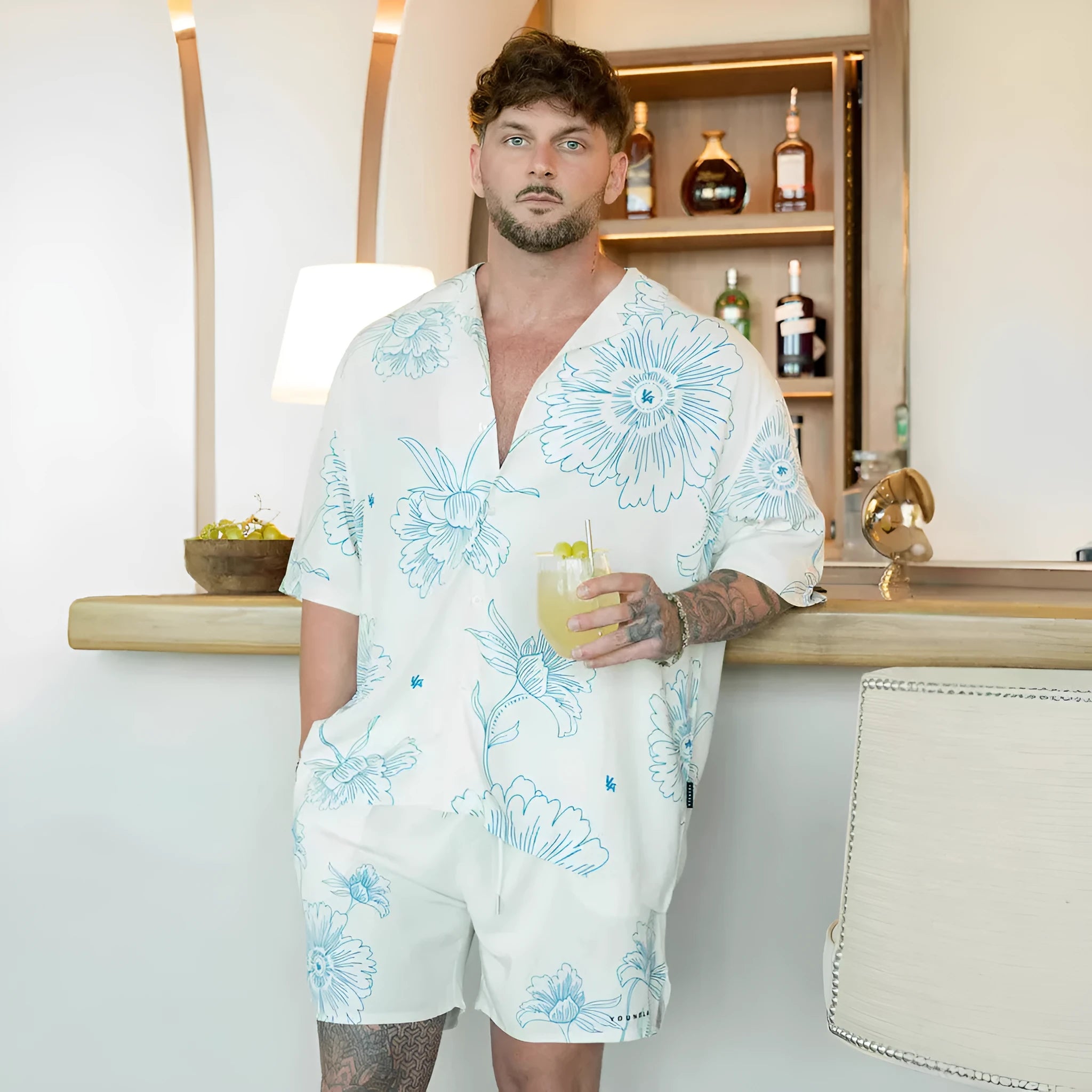 Man wearing a loose fit, short sleeve printed floral top in a neutral colour