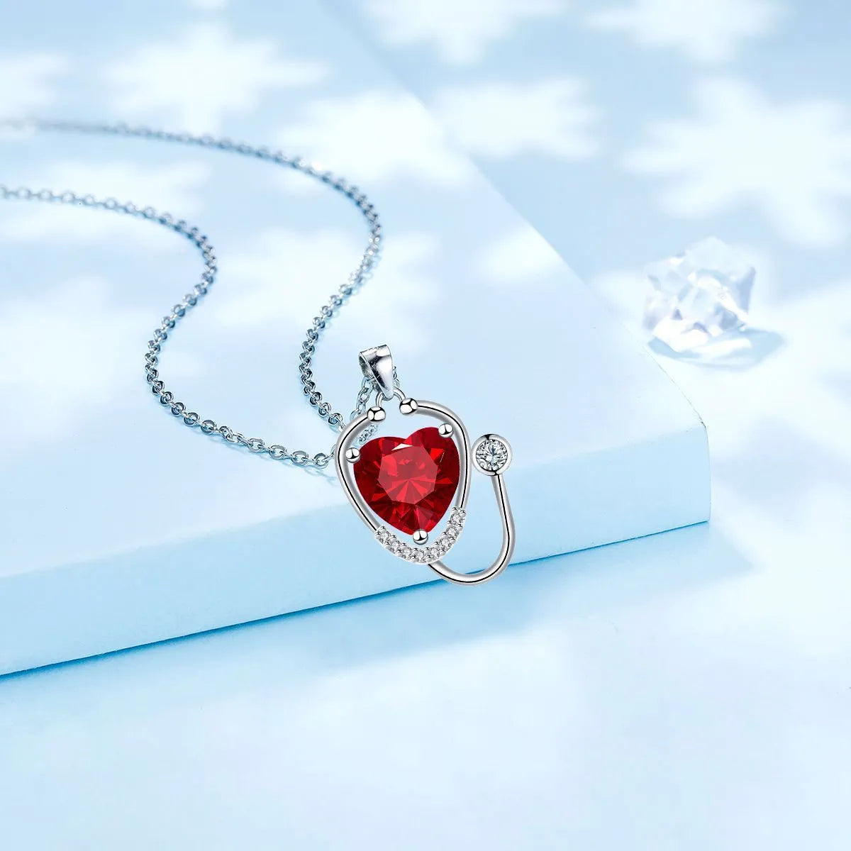 Red diamond coloured women's necklace with stethoscope, wings and cross pendant design