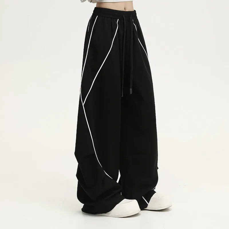 Black and white striped wide-leg hip hop trousers with front pleats on a mid-waist.