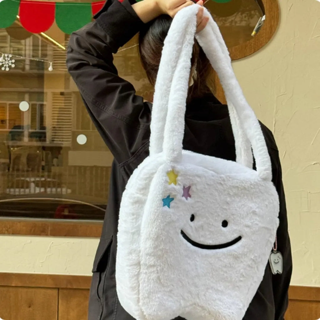 White plush tote bag with a cute teeth pattern, showing the shoulder strap and zipper closure