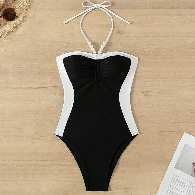 Black and white women's one-piece swimsuit with spaghetti straps and slimming cut