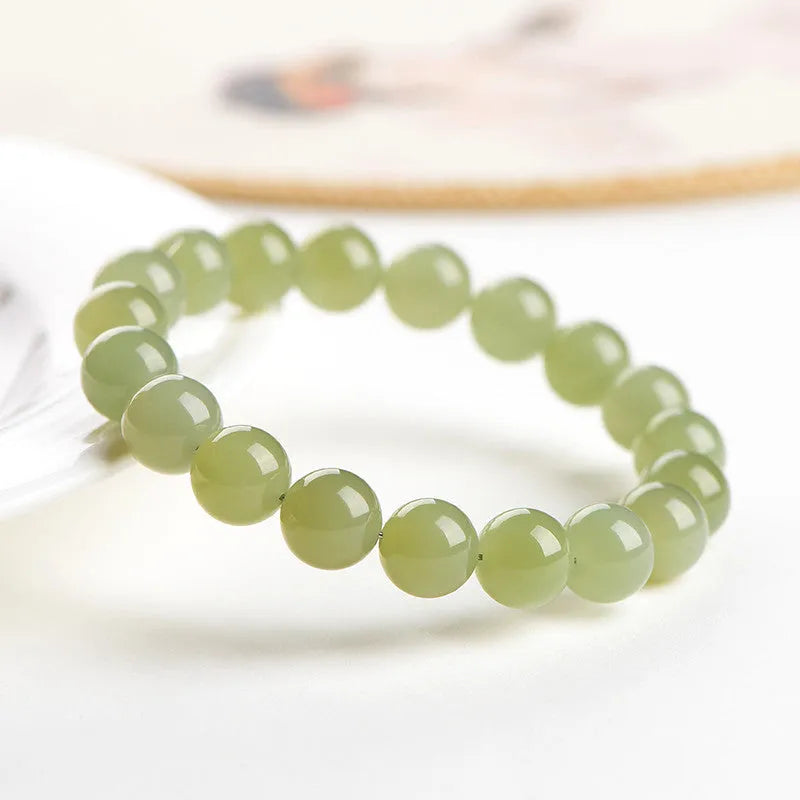 Polished Hetian jade ball bracelet showing spherical beads in ice-like clear water colour on a wrist.