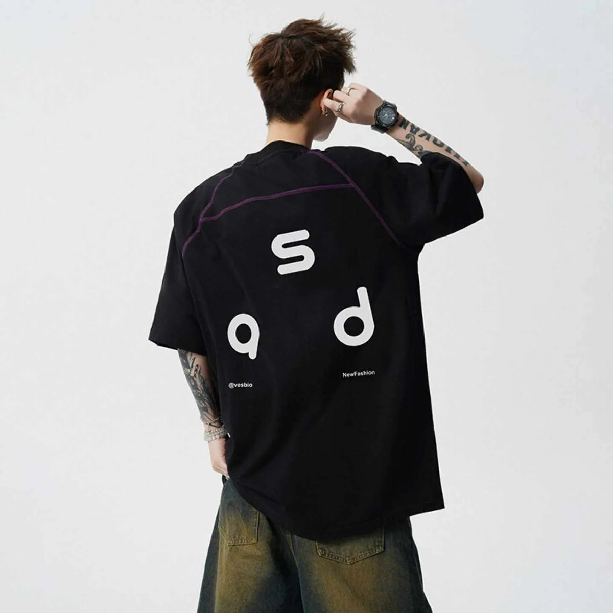 Loose-fit black cotton short-sleeve t-shirt with white letter print graphic on a mannequin.