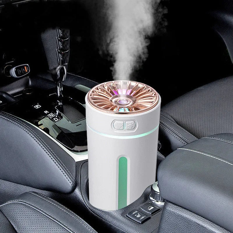Black wireless ultrasonic humidifier with colourful lights, shown next to a USB cable on a desk.