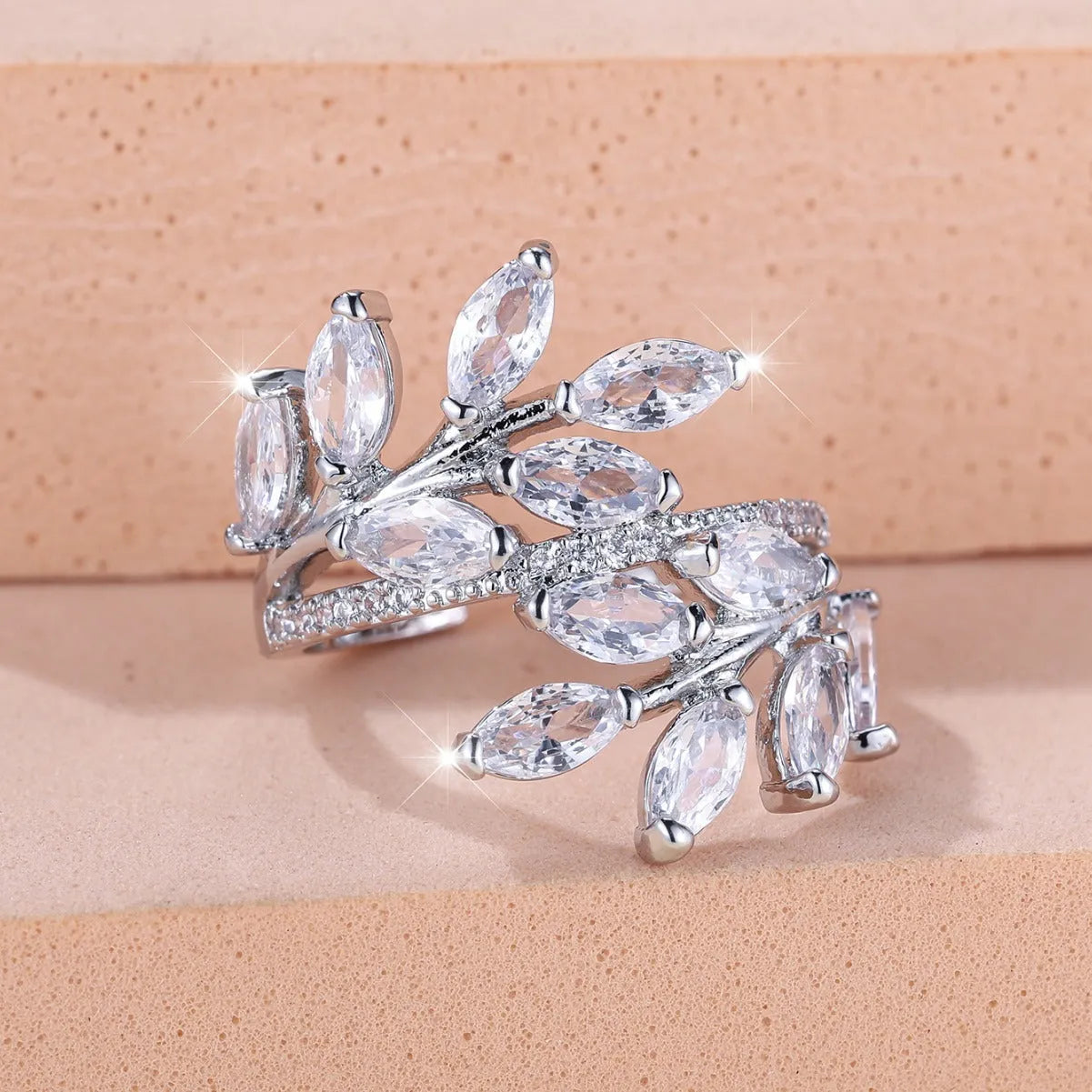 Adjustable copper leaf ring with zircon detailing in multiple colour options on display