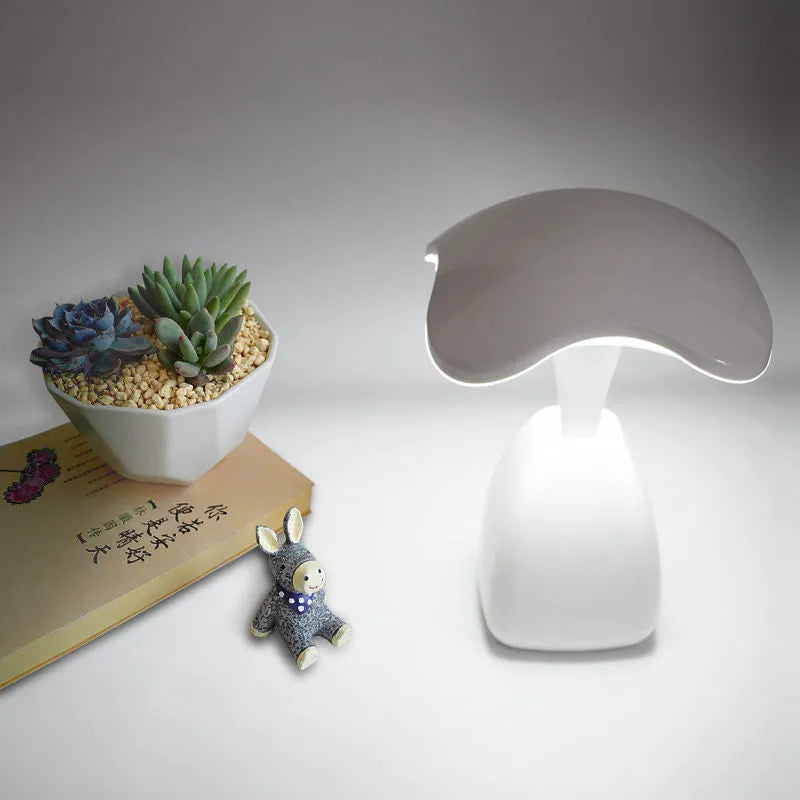 White modern LED desk lamp with a plastic shade and touch switch on a table.