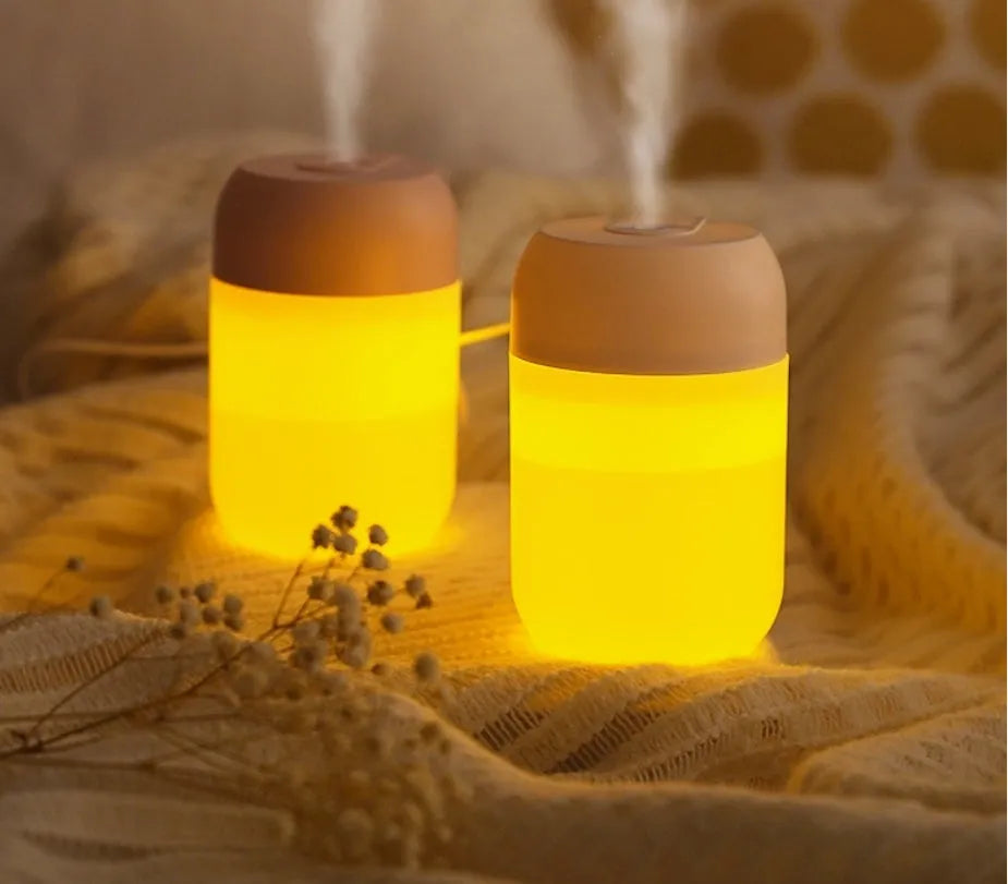 White cylindrical mini humidifier with USB cable on a desk
