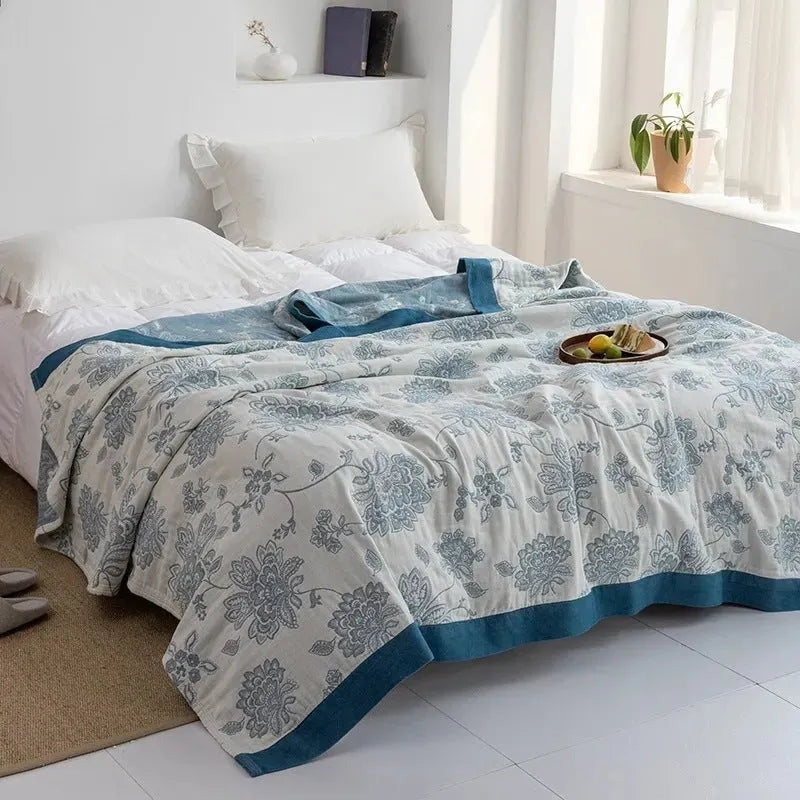 Blue five-layer gauze cotton bed sheet blanket folded, showing modern simplicity pattern and thickness.