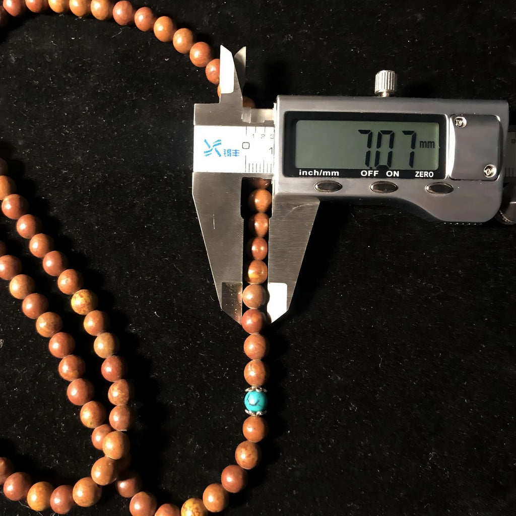 Stone bracelet with 108 geometric beads showing hand-polished finish