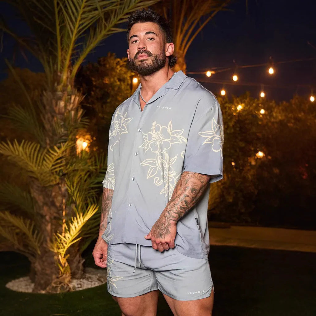Man wearing a loose fit, short sleeve printed floral top in a neutral colour