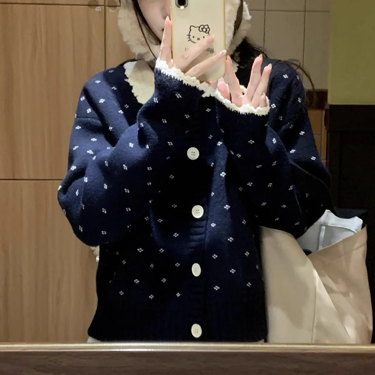 Navy blue floral patterned knitted cardigan coat with a white Peter Pan collar and button front.