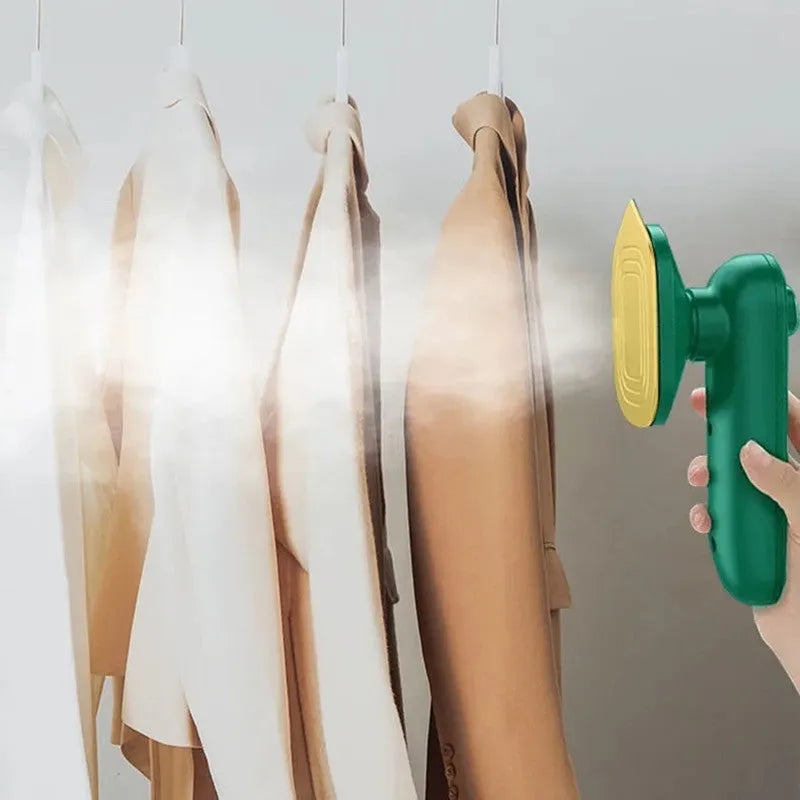 Dark green portable handheld steam iron with ceramic panel, shown next to clothing on a hanger.