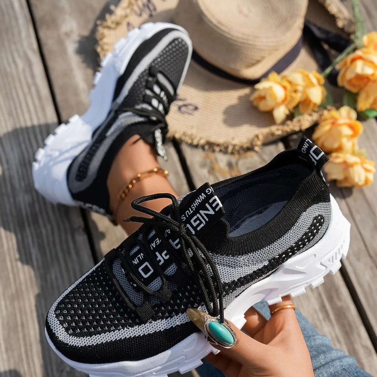 Women's Flyknit mesh sneakers in grey and white with a flat rubber sole and lace-up front.