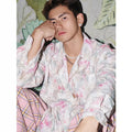 Women's pink floral long sleeve shirt with embossed pattern and loose fit on hanger