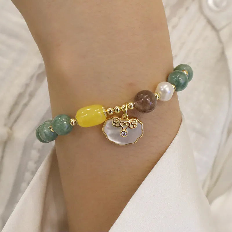 Green jade shell bracelet for women on a wrist, showing the natural stone colour and shell design detail.
