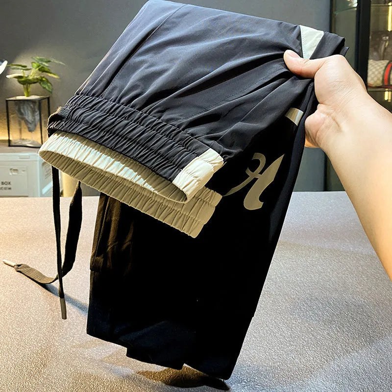 Black ultra-thin ice silk ankle banded cropped trousers for men displayed flat