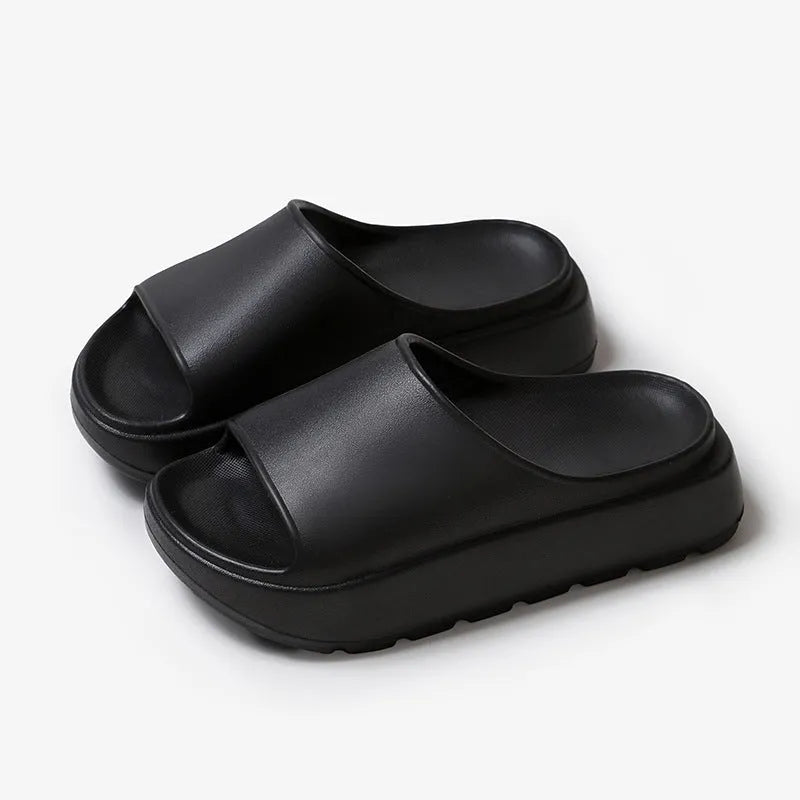 Women's thick-soled EVA beach slippers in beige, shown from the side on a sandy surface.