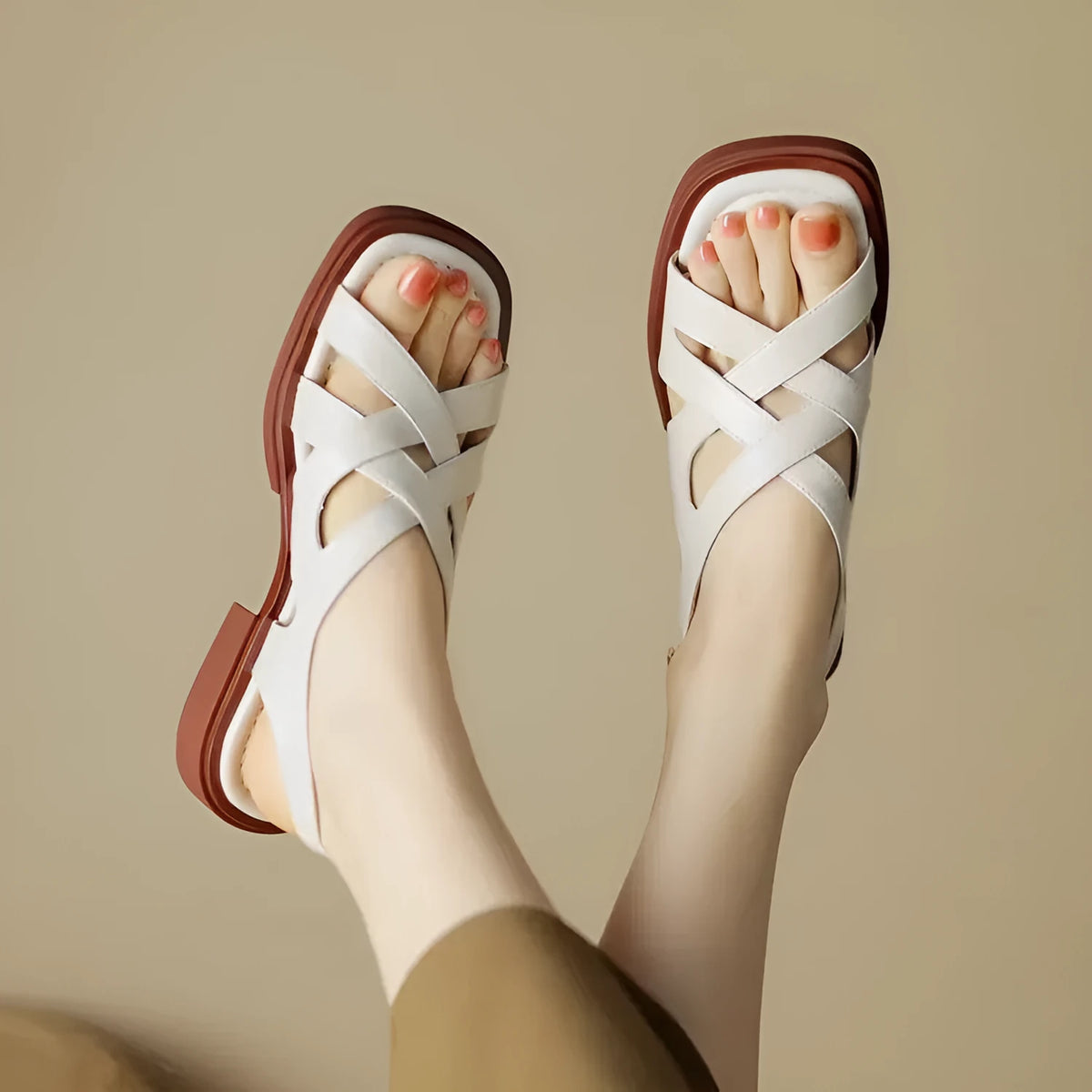 Glossy black patent leather women's sandals with a square toe and cross strap design.