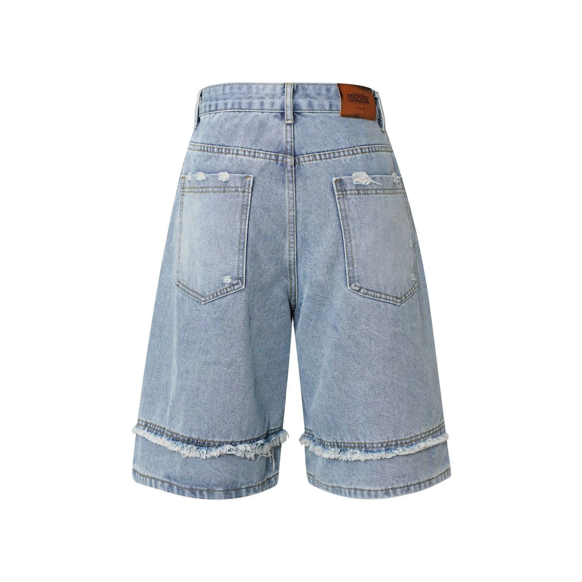 Distressed raw edge denim shorts in a straight-leg cropped fit on a hanger.