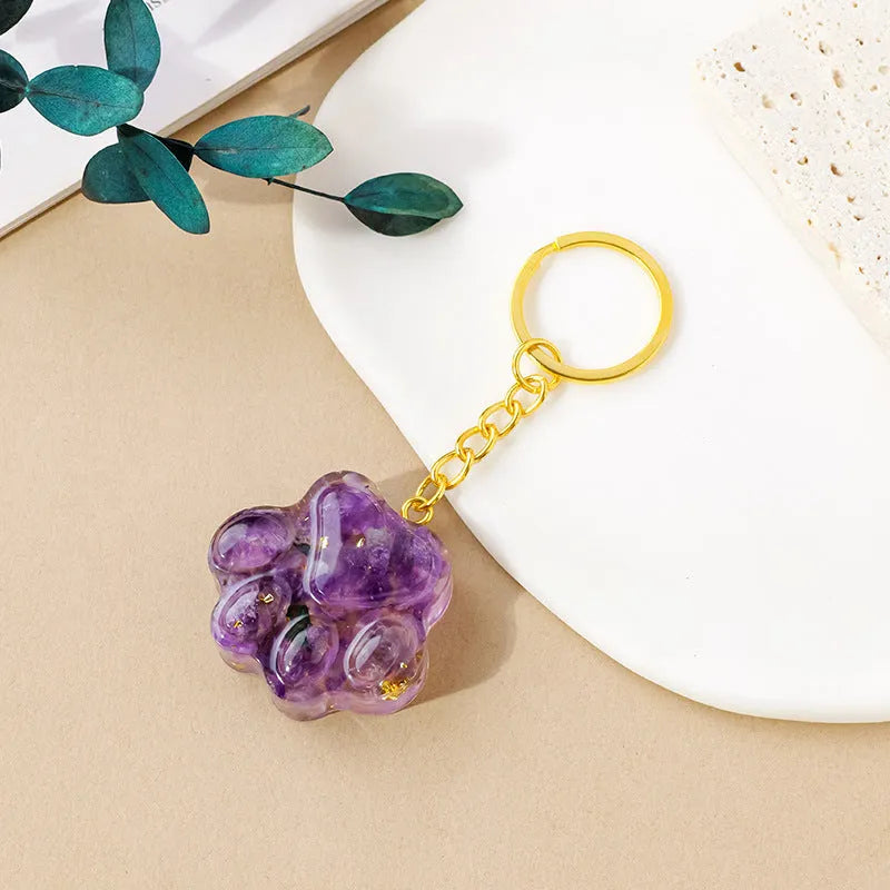 Small handcrafted crystal cat's paw shaped keychain pendant on a keyring.
