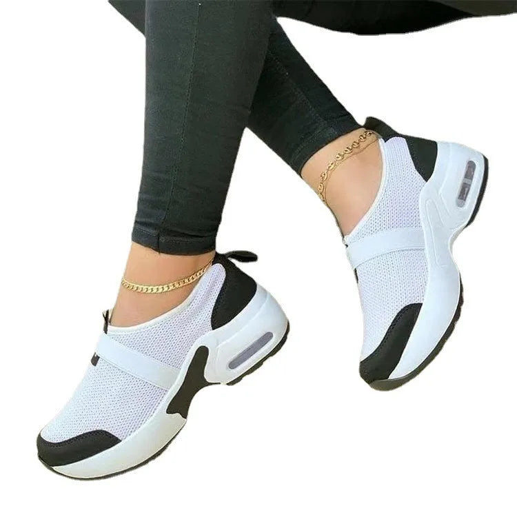 Women's flat sneakers in light grey with mesh upper, round toe, and rubber sole.