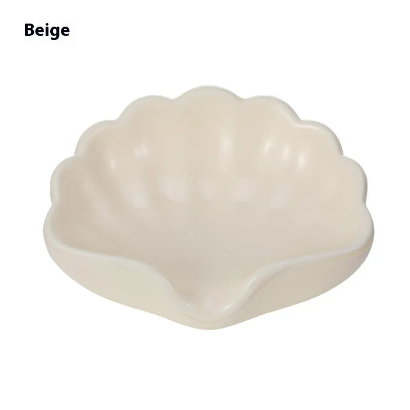 White plastic shell-shaped soap dish for bathroom countertop or wall.