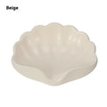 White plastic shell-shaped soap dish for bathroom countertop or wall.
