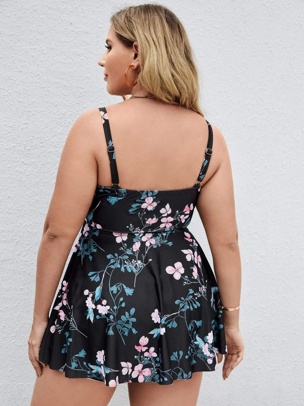 Women's floral print one-piece swimsuit on a hanger, showing split colour design