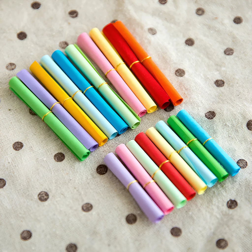 Assortment of colourful mini paper scrolls with metal eyelets for drift bottle messages and crafts.