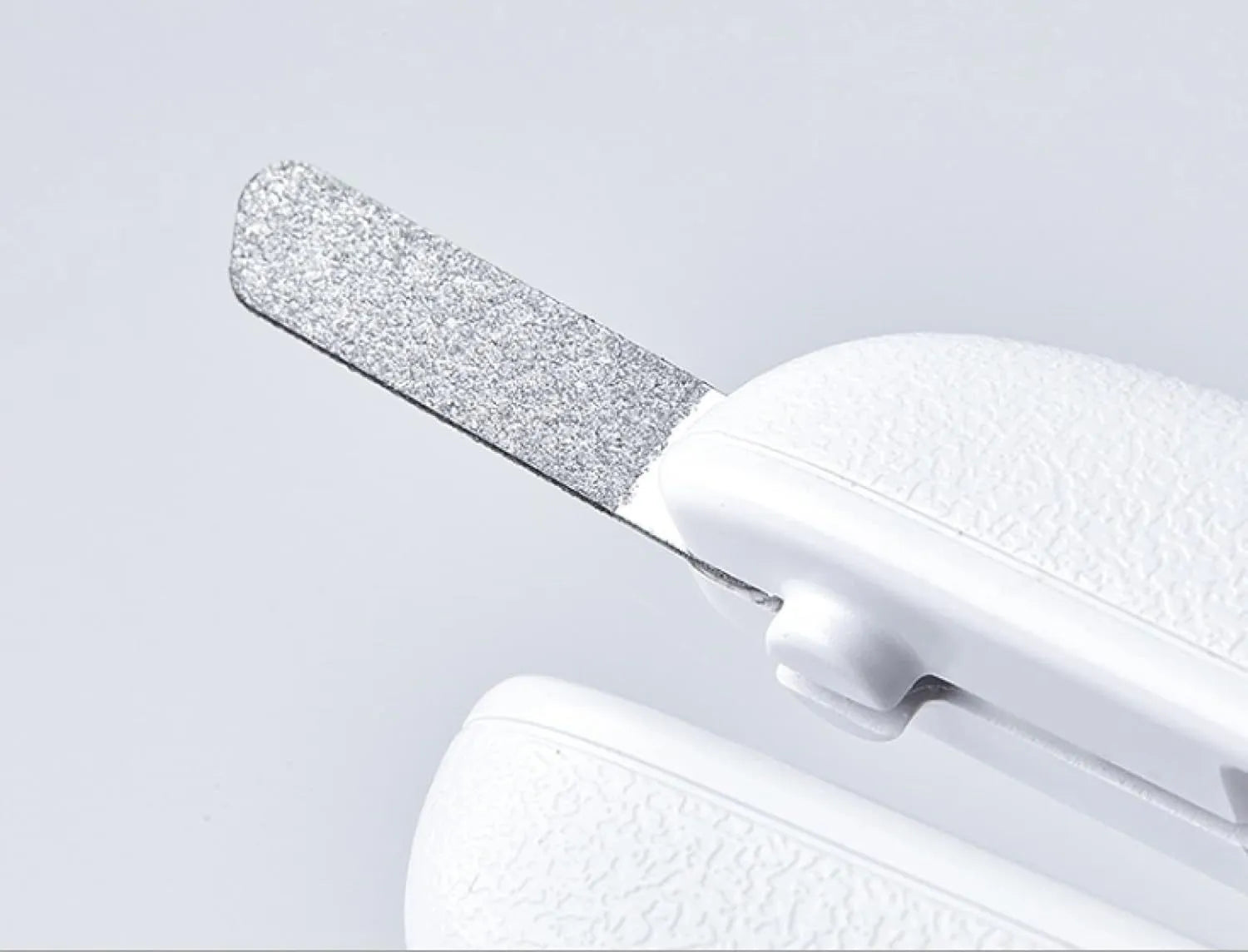 White pet nail clipper with LED light on handle and transparent anti-splash guard surrounding the blades.