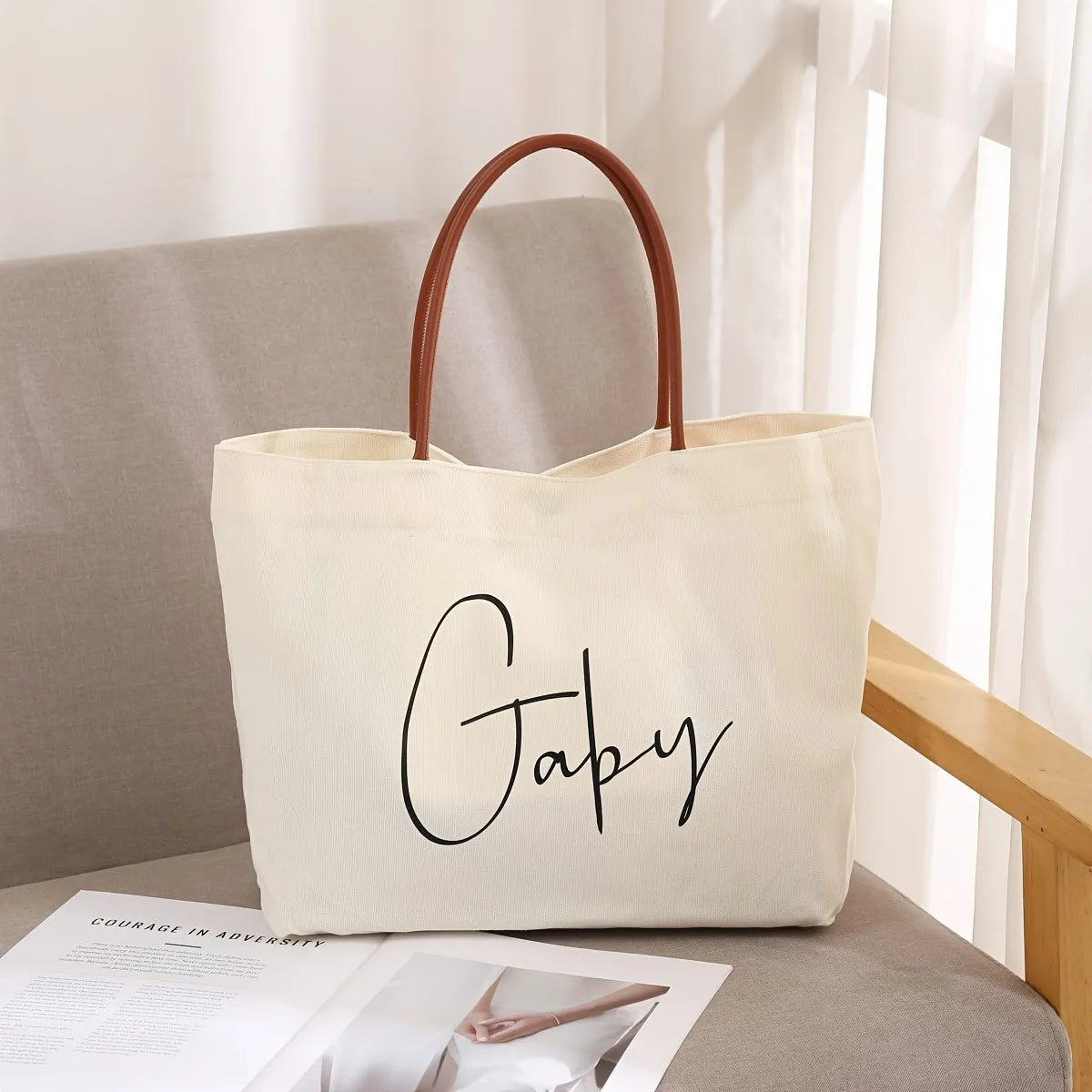 Beige white and white canvas tote bag with long handle straps.