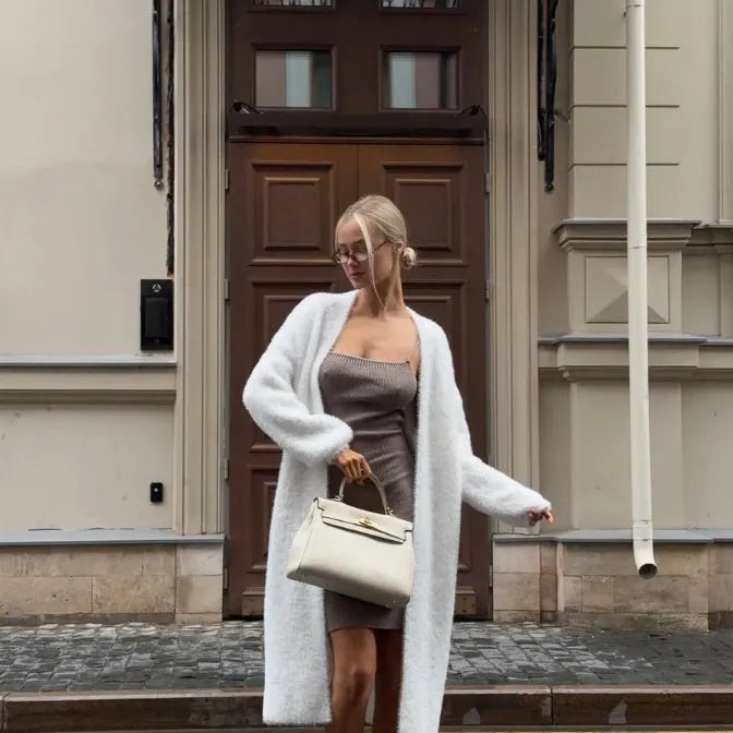 White longline knitted cardigan jacket with long sleeves on a hanger.