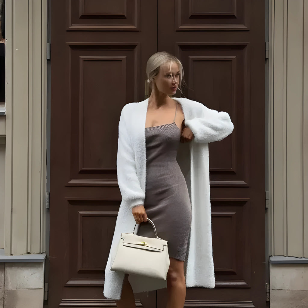 White longline knitted cardigan jacket with long sleeves on a hanger.