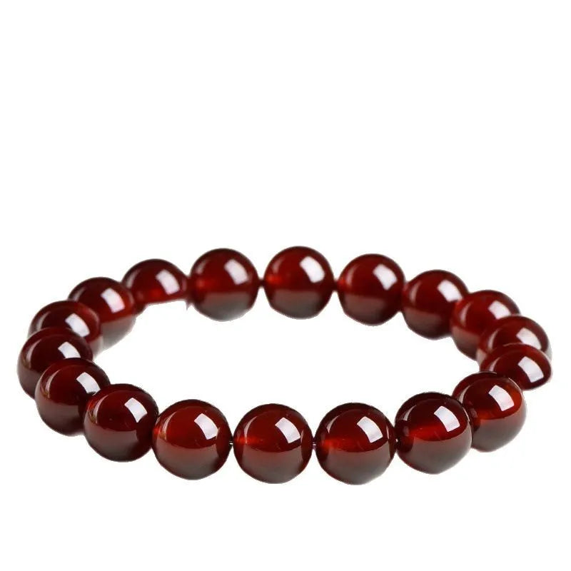 Natural Orange Red Garnet ball bracelet with a Ruyi charm on a white background