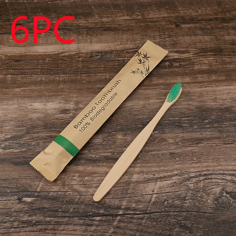 Ten bamboo toothbrushes with coloured handles and charcoal bristles laid out side by side.