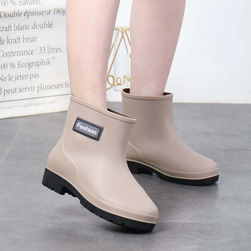 Women's mid-calf PVC rain boot in black on a wet surface