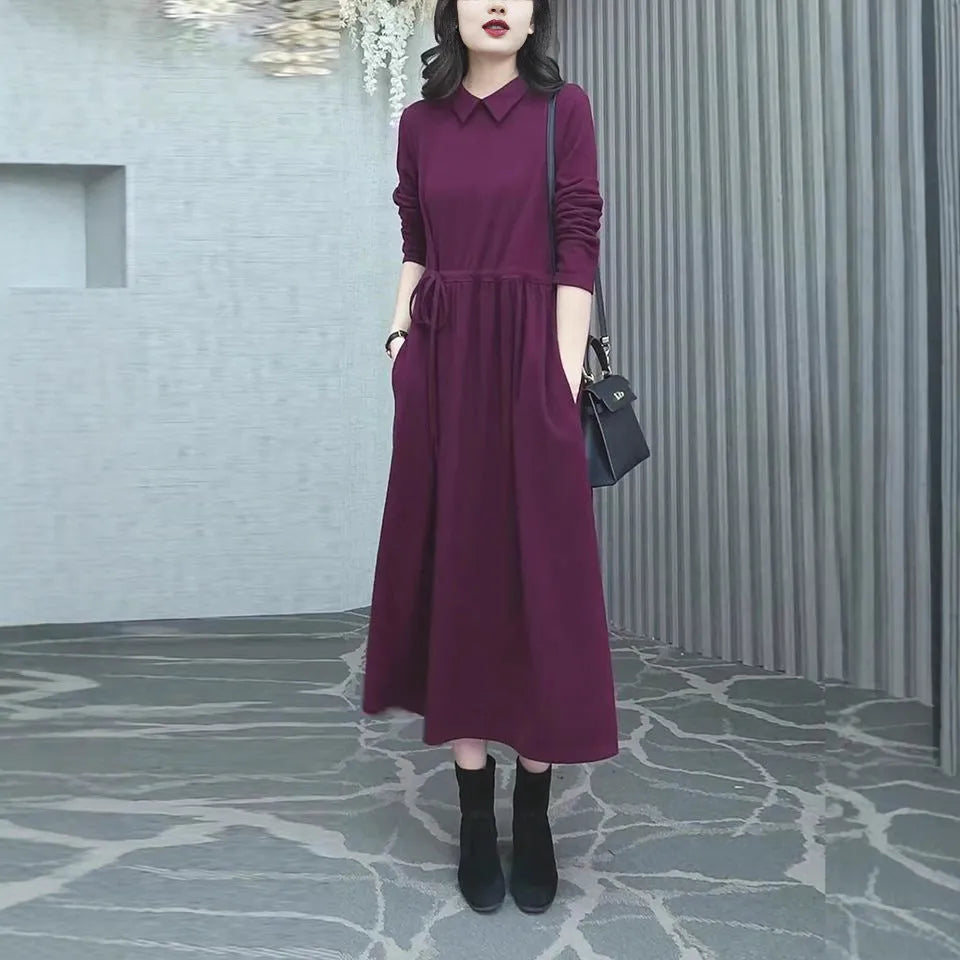 Purplish red plus size long sleeve long skirt dress for women on a hanger.