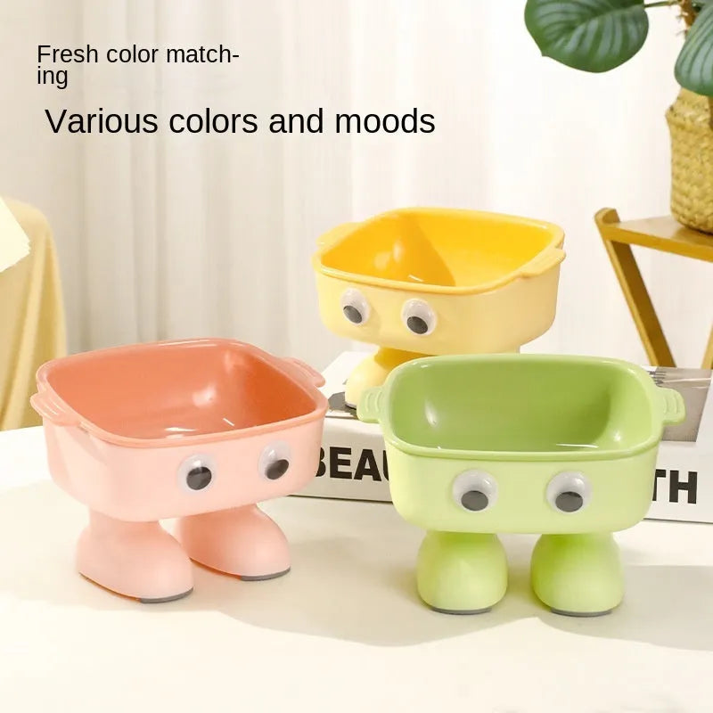 Green cartoon robot shaped elevated cat bowl with tilted food dish on anti-slip base