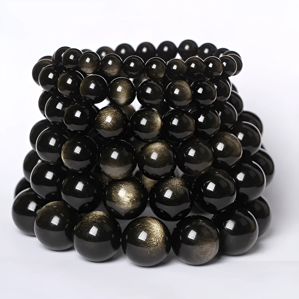 Hand-woven round obsidian bracelet in black stone, shown on a wrist.