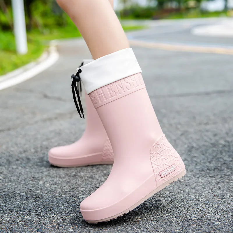 Women's solid colour PVC rain boots with non-slip soles in apricot, black, brown, and pink.