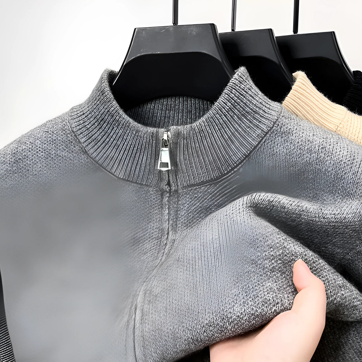 Man wearing a grey, loose-fit, stand collar cardigan with a front zipper.
