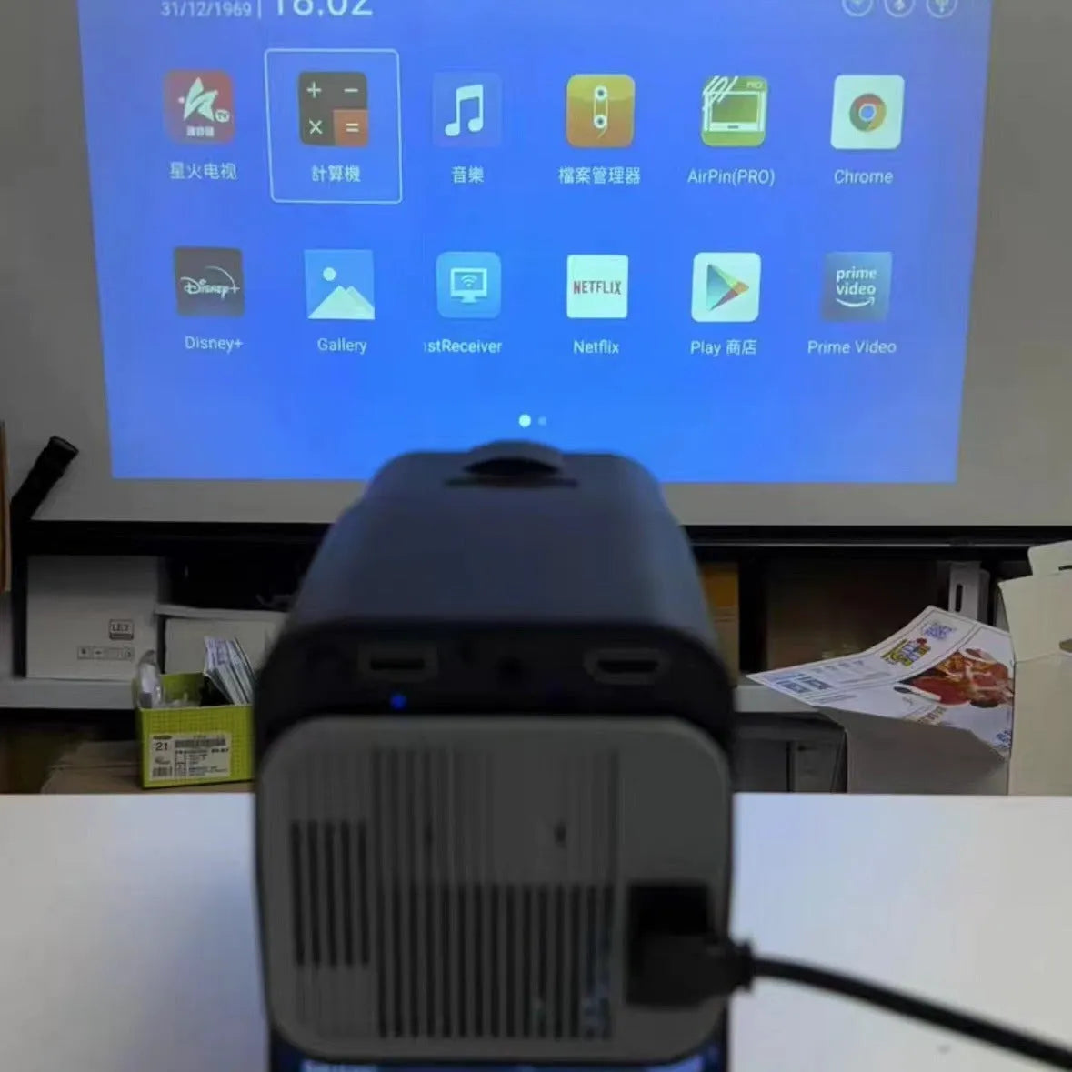 Wireless home gaming projector with HD 720p resolution displayed alongside gaming console
