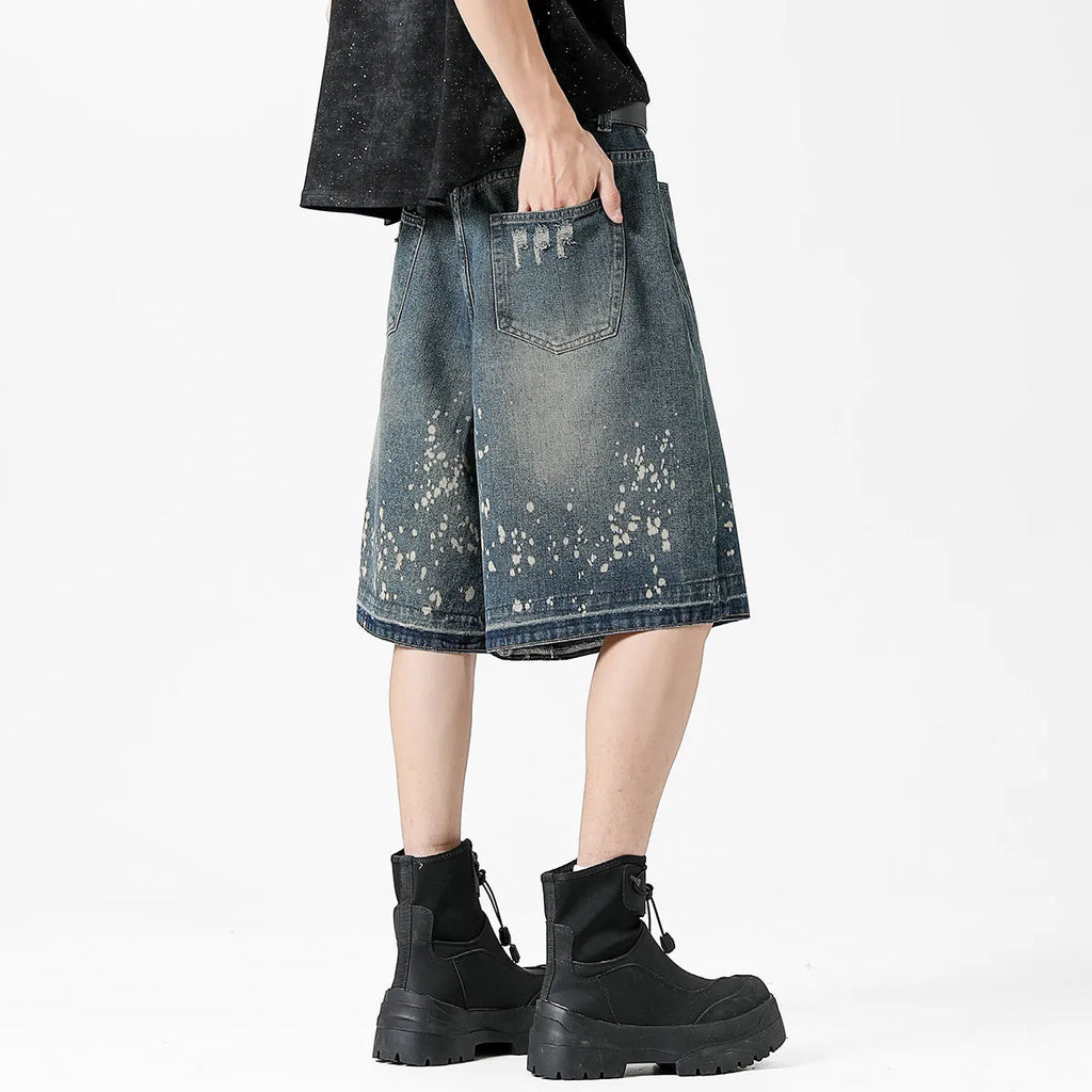 Men's straight cut denim shorts with retro blue wash and ripped splash ink details
